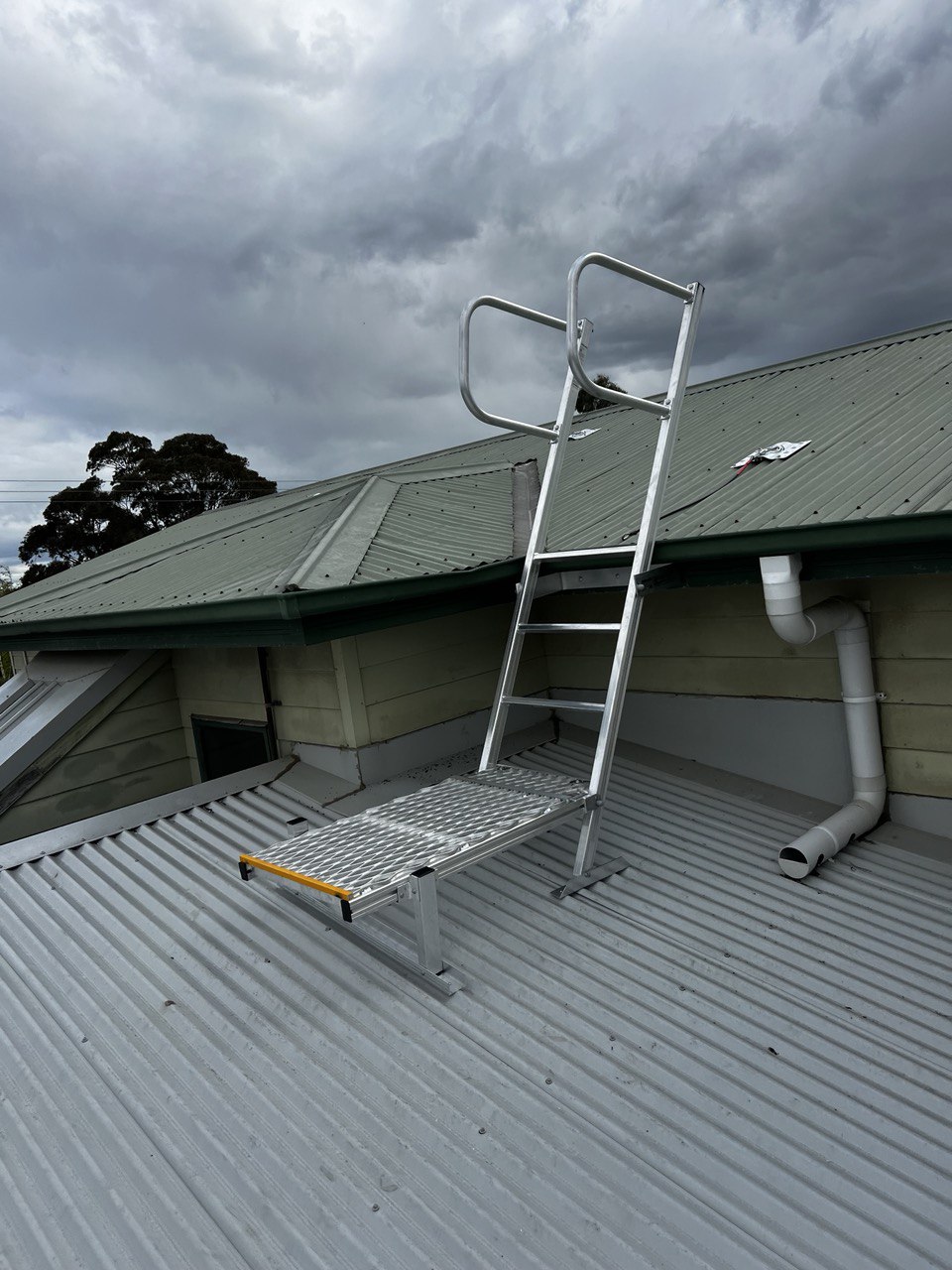 Roof access ladder installation on school building